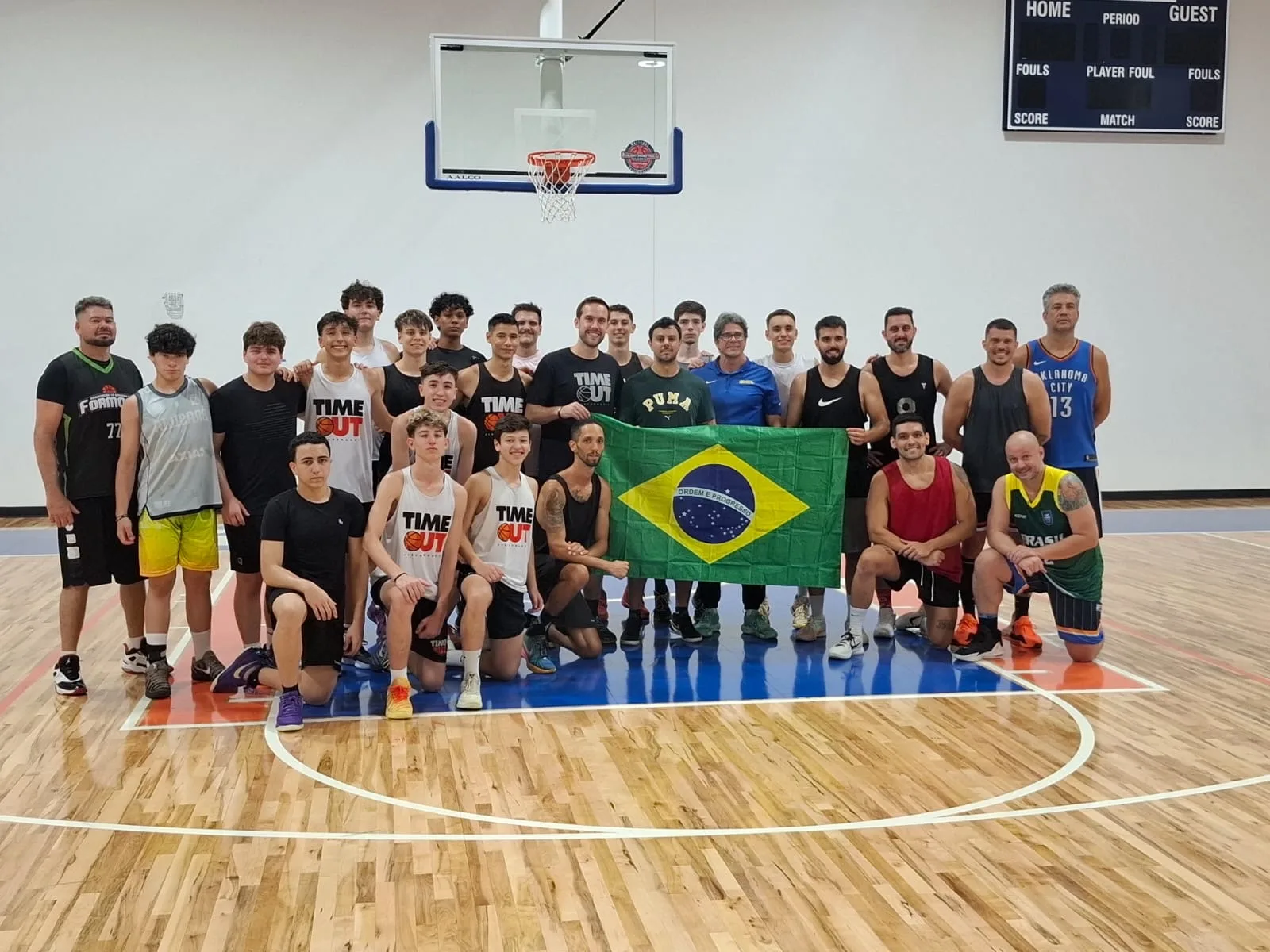 Atletas brasileiros da Plus1 Academy em quadra com bandeira do Brasil